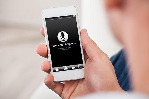 Over the shoulder view of the blank screen on a smartphone or mobile phone held in a mans hand