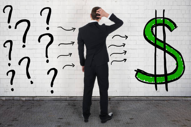 istock Confused Businessman Looking At Question Marks And Dollar Sign 917882026