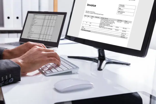 Photo of Businessperson Checking Invoice On Computer