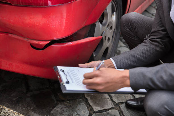 istock Insurance Agent Writing On Clipboard After Car Accident 917885068