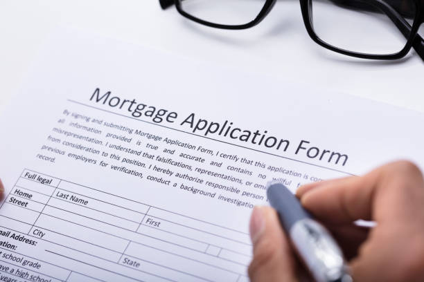istock Human Hand Filling Mortgage Application Form 917885126
