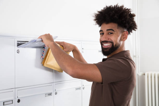 メールボックスで男を入れて文字 - postal worker delivering mail post office ストックフォトと画像