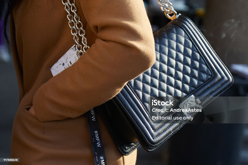 Woman With Black Chanel Leather Bag With Silver Chain And Beige