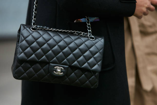 femme avec sac de cuir noir chanel avec chaine en argent - brand name photos et images de collection