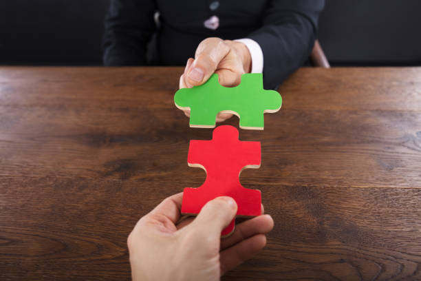istock Two Businessmen Joining Jigsaw Pieces 917891802