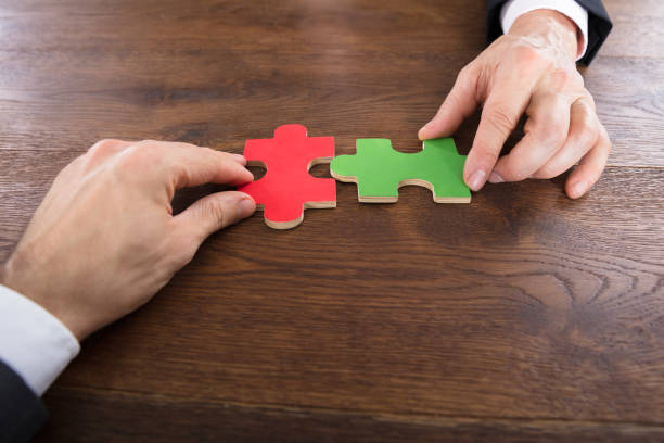 istock Two Businessmen Joining Jigsaw Pieces 917891814