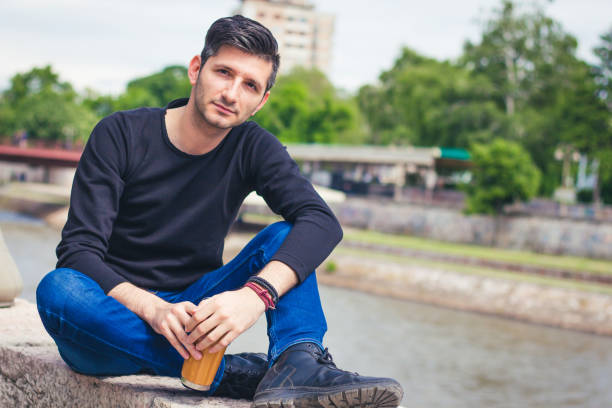 istock man sitting near the city river relaxing 917892578