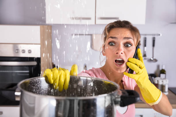 istock Woman Calling Plumber To Fix Water Leaking From Ceiling 917892724