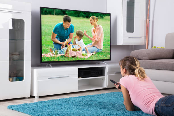 istock Woman Lying On Blue Carpet And Watching Television 917892988