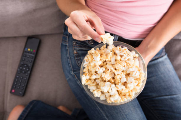 istock Woman Sitting On Sofa Eating Popcorn 917893050