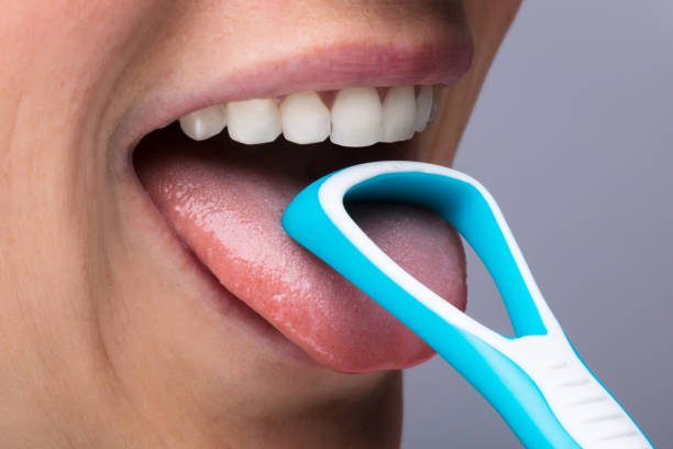 istock Woman Cleaning Tongue With Cleaner 917893064
