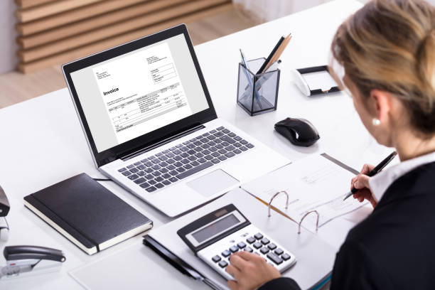istock Businesswoman Calculating Invoice Using Calculator And Laptop 917893174