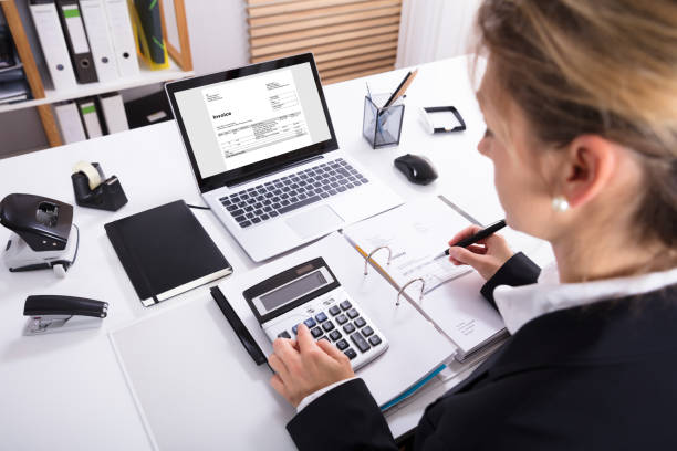 istock Businesswoman Calculating Invoice Using Calculator And Laptop 917893188