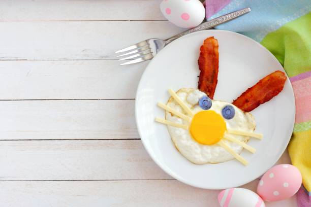 istock Easter breakfast, table scene with bunny face over white wood 917893212