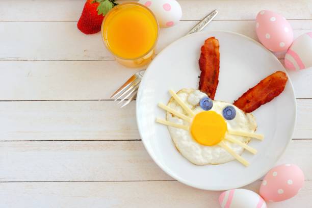Easter breakfast, table scene with bunny face over white wood