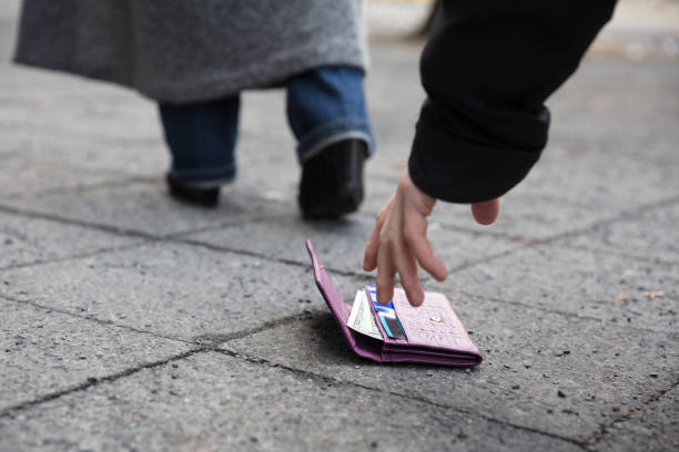 istock Man Picking Up A Lost Purse 917895888