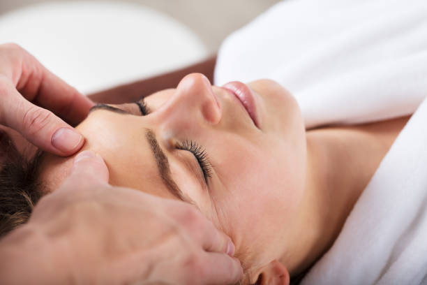 istock Therapist Giving Massage On Woman's Forehead 917895966