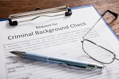 Close-up Of Criminal Background Check Application Form With Pen At Desk