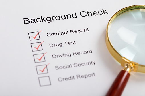 High Angle View Of Magnifying Glass Over Background Check Form