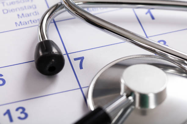 close-up of stethoscope over calendar - appointment reminder doctor calendar imagens e fotografias de stock