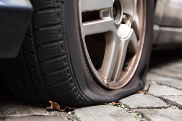 Damaged Flat Tire Of A Car Close-up Of A Damaged Flat Tire Of A Car On The Road piercing stock pictures, royalty-free photos & images