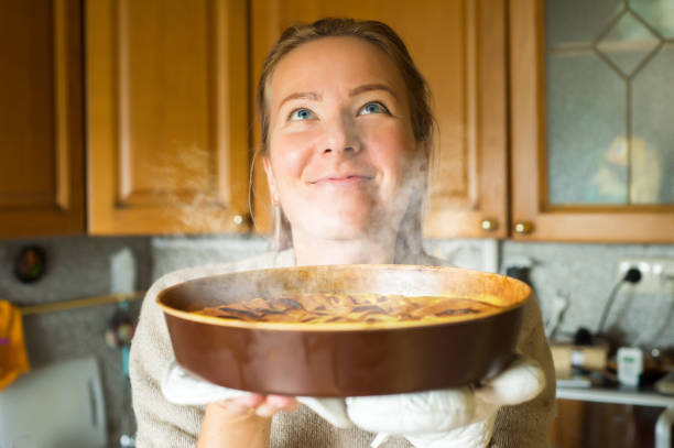 istock Young woman holding a baking tray with a ready cake 917897392