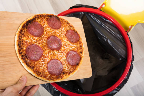istock Person Throwing Salami Pizza In Dustbin 917900144