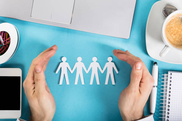 istock Businessman Protecting The Paper Cut Out Human Figure 917901200