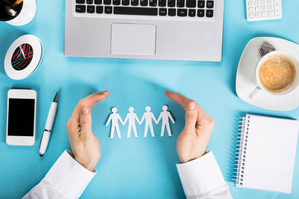istock Businessman Protecting The Paper Cut Out Human Figure 917901232