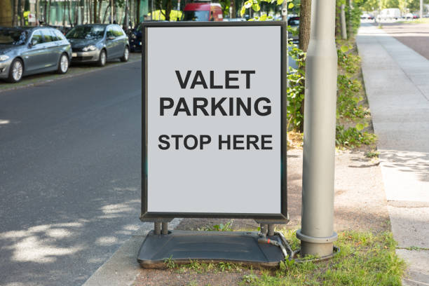 Valet parking sign on board by street in city