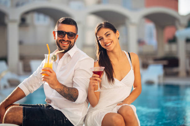 loving couple spending vacation on tropical resort swimming pool.newlyweds honeymoon on seaside.couple in true love.flirting and showing emotions. - honeymoon beach swimming pool couple imagens e fotografias de stock