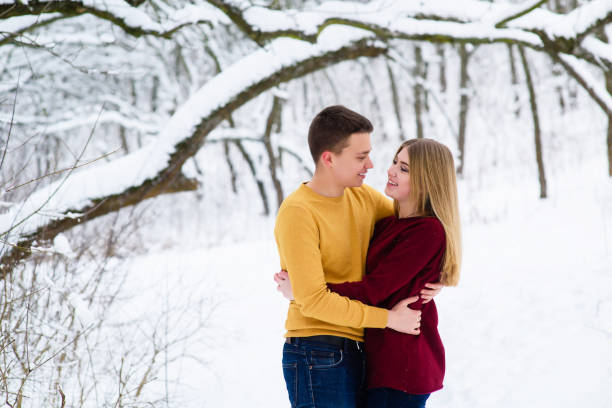 istock Young couple hugs in winter forest 917913578