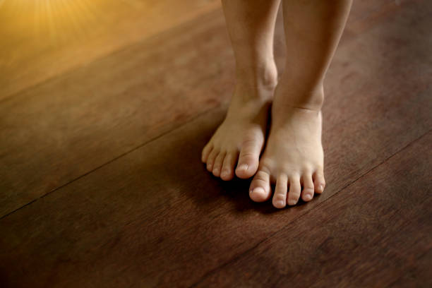 istock Children's bare feet on wooden floor. 917914524