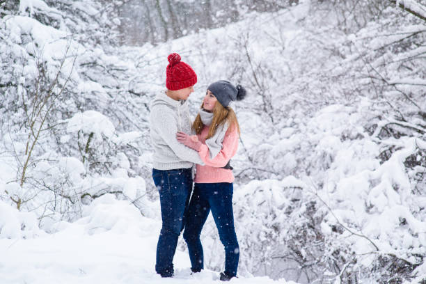 istock Stylish couple in knitted clothes during snowfall 917919526