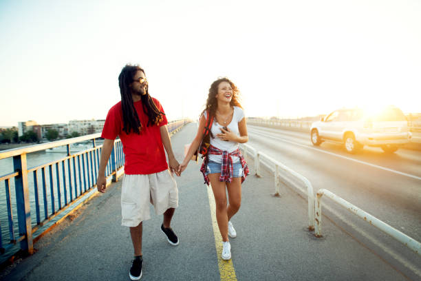 istock Young hipster couple walking on the bridge at sunset. 917926744