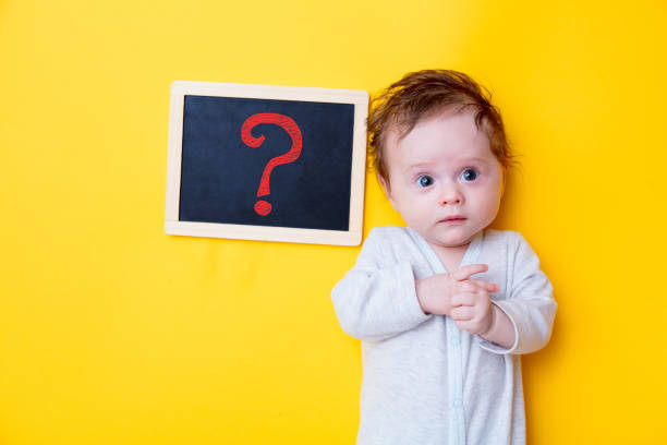 little baby with black board and red question stock photo