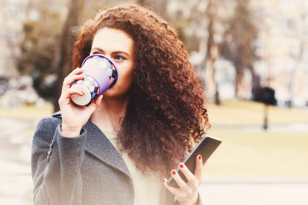 istock Young businesswoman texting and drinking coffee 917938248