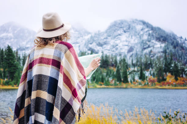 istock Woman traveling among mountains with map, boho style 917940356