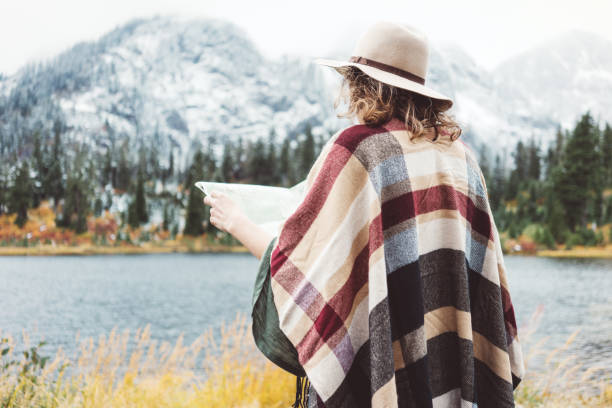 istock Woman traveling among mountains with map, boho style 917940510