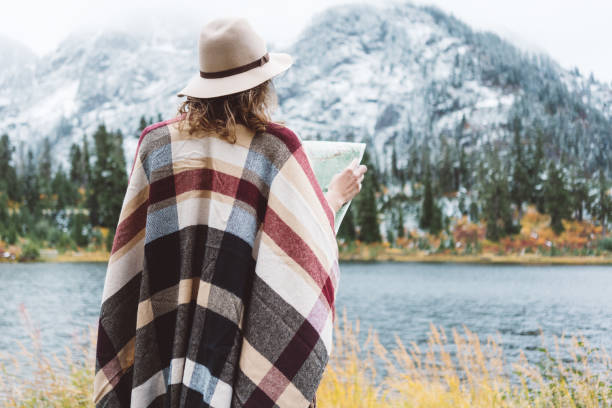 istock Woman traveling among mountains with map, boho style 917940600