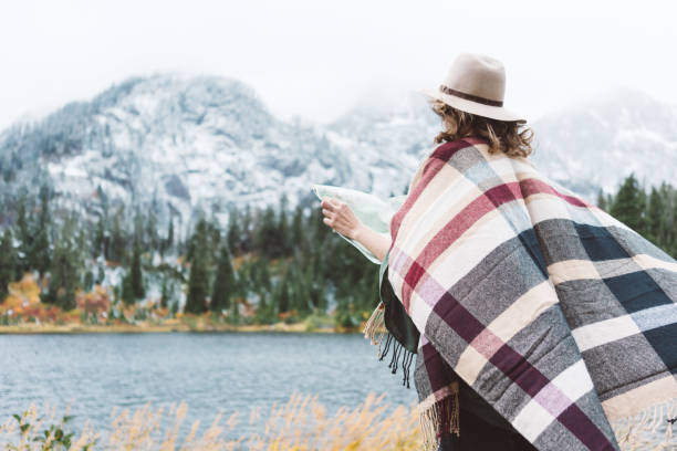istock Woman traveling among mountains with map, boho style 917940636