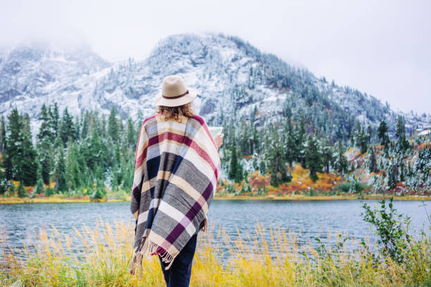 istock Woman traveling among mountains with map, boho style 917940640