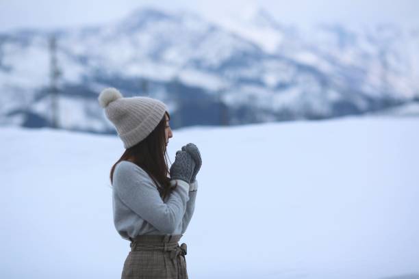 istock Young Woman watching something at snow field 917940832