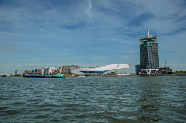 Ship and modern buildings on the banks of the Canal Buiten-Ij in Amsterdam. Amsterdam, northern Netherlands - June 27, 2017. Ship and modern buildings on the banks of the Canal Buiten-Ij in Amsterdam. Famous for its huge cultural activity, graceful canals and bridges. hull house stock pictures, royalty-free photos & images