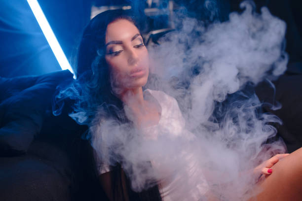 istock woman vaping electronic hookah. Vape concept 917955072