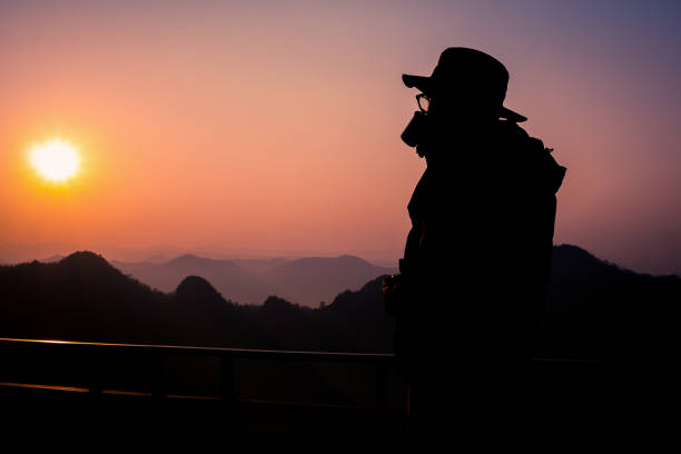istock Silhouette Handsome man looking forward with binoculars at a mountain and drinking coffee 917955362
