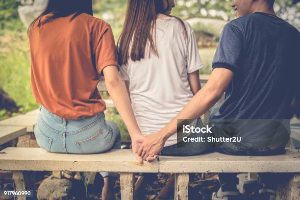 Boyfriend And Another Woman Grab Hands From Behind Together Without Sight Of His Girlfriend Paramour And Divorce Concept Social Problem And Cheating Couples Theme Teen Adult And University Theme Stock Photo - Download Image Now