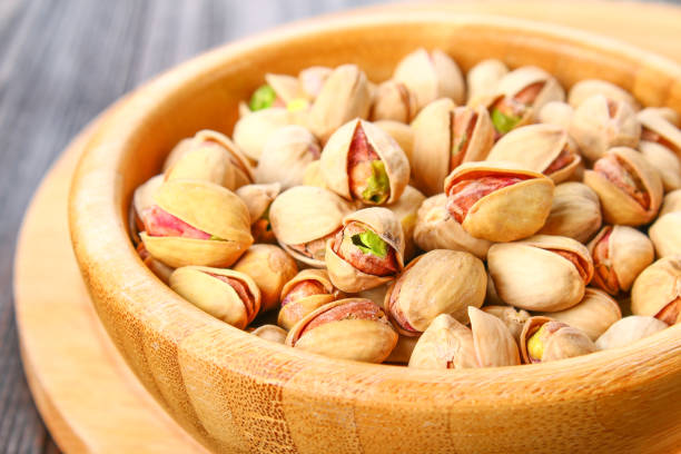 istock Dish full of pistachios with more pistachios on side. 917964646