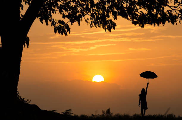 Woman holding a sunset umbrella.