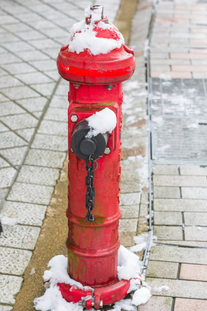 istock Red fire hydrant water pipe and snow at street 917975202